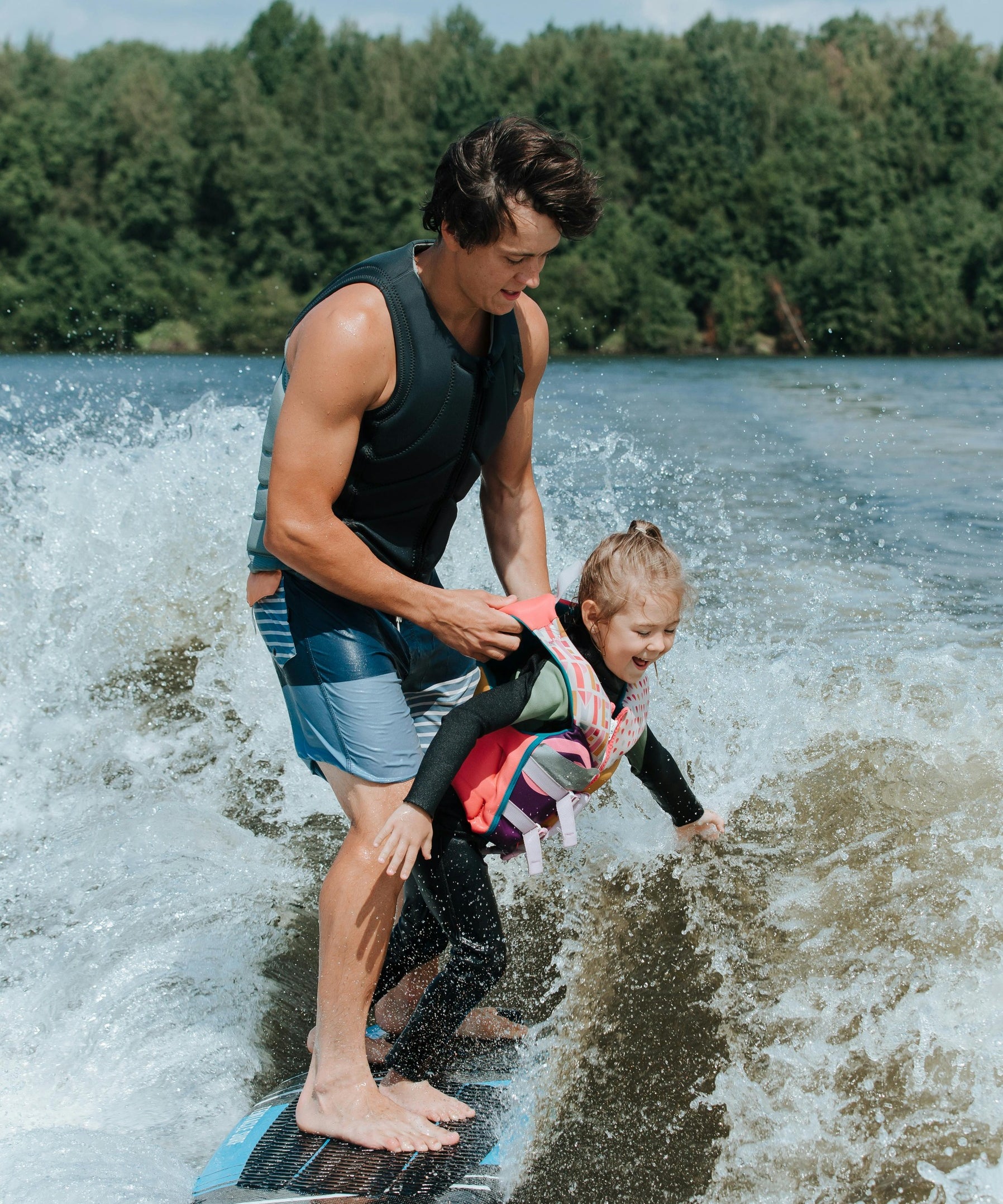Man surfing with daughter showing the active outdoorsy lifestyle that nuwave products support